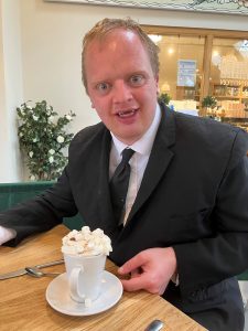 Jamie at Doddington Hall with a hot chocolate topped with whipped cream and marshmallows
