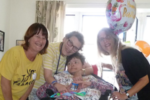 Lady in a wheelchair surrounded by her family