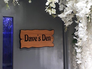 Wooden sign saying 'Daven's Den' on a grey door