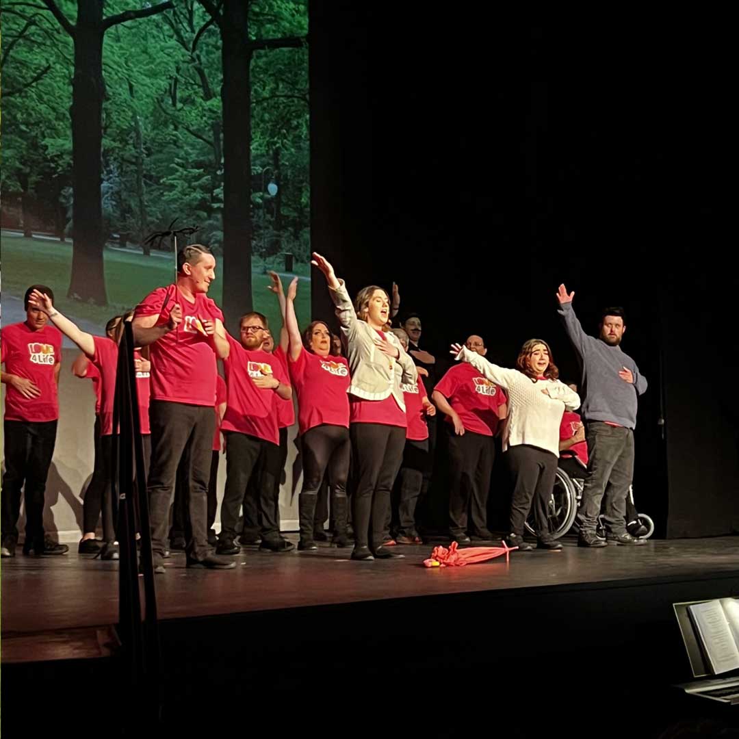 Group of people wearing red t-shirts performing on a stage