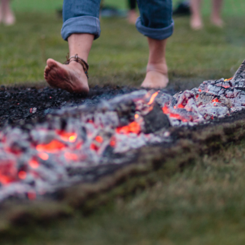 Close-up of person walking barefoot over hot ashes
