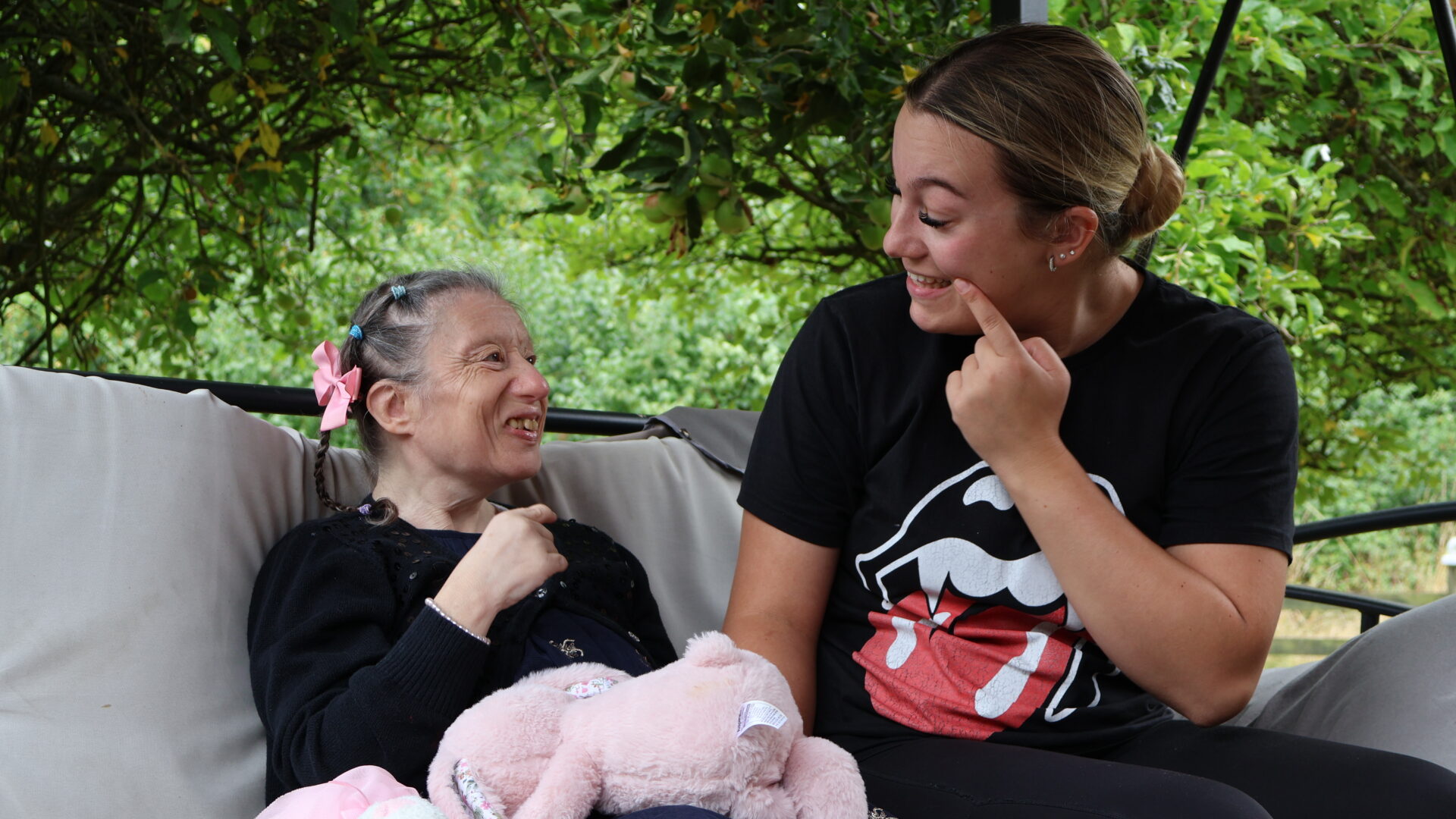 Two adults laughing together in a garden