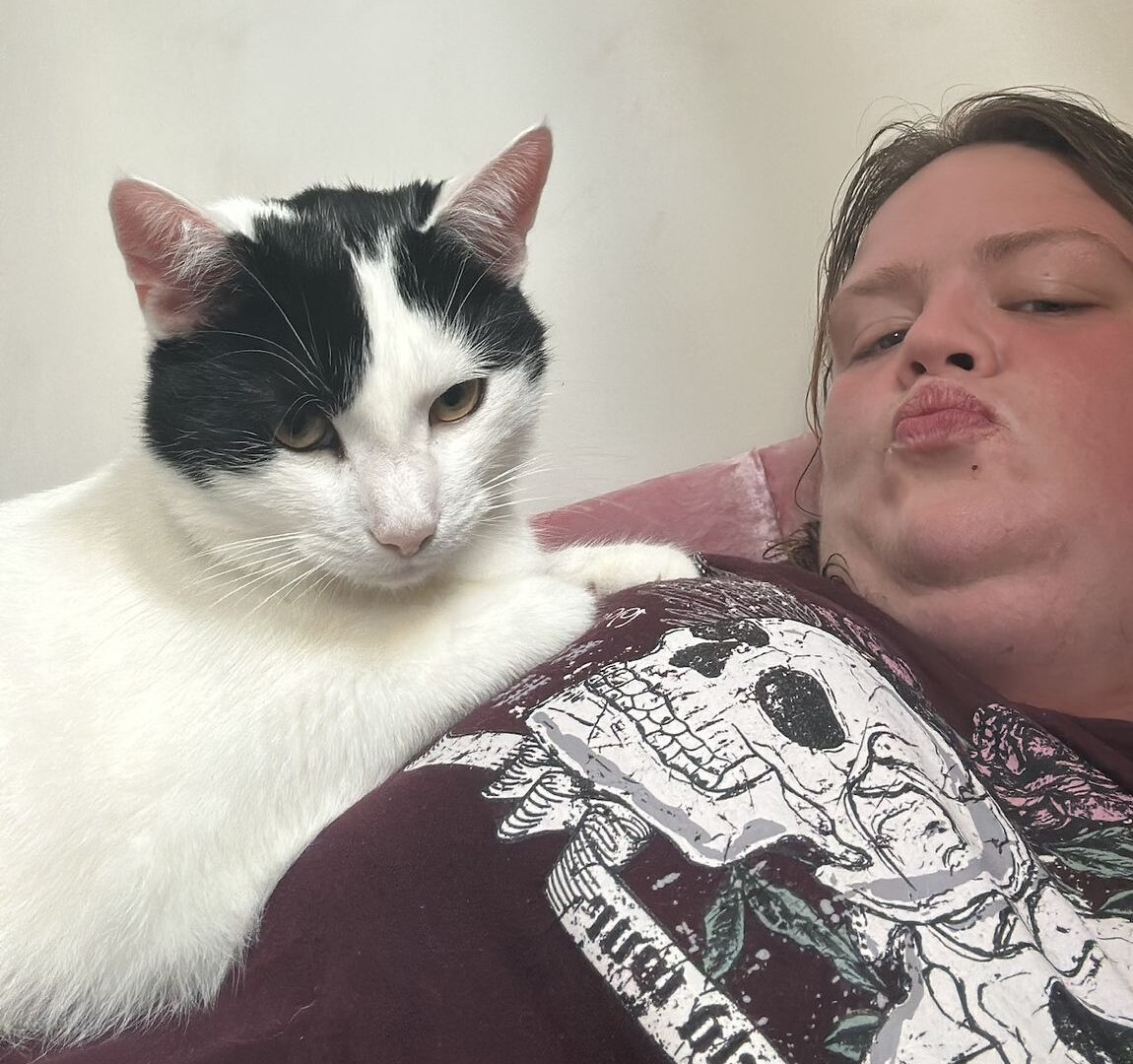 Sarah relaxing with her black and white cat Ross
