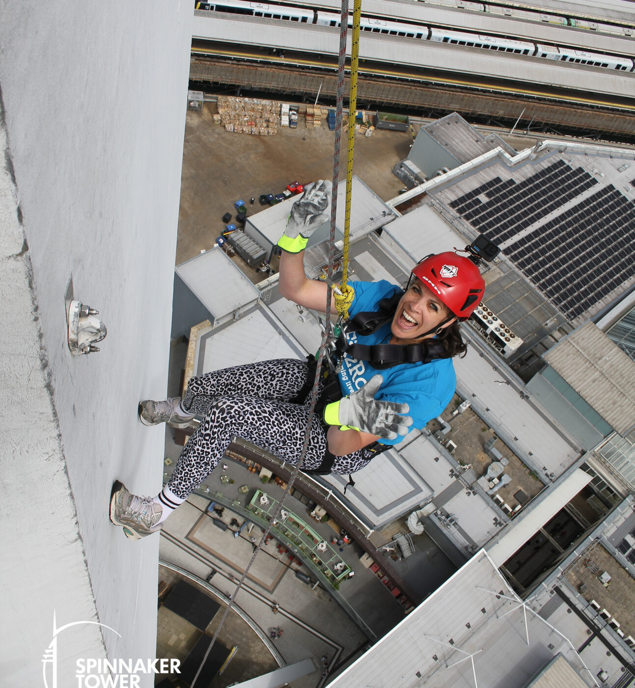 Zoe smiles as she abseils down Portsmouth’s Spinnaker Tower, still high above the ground during a FitzRoy fundraising challenge.
