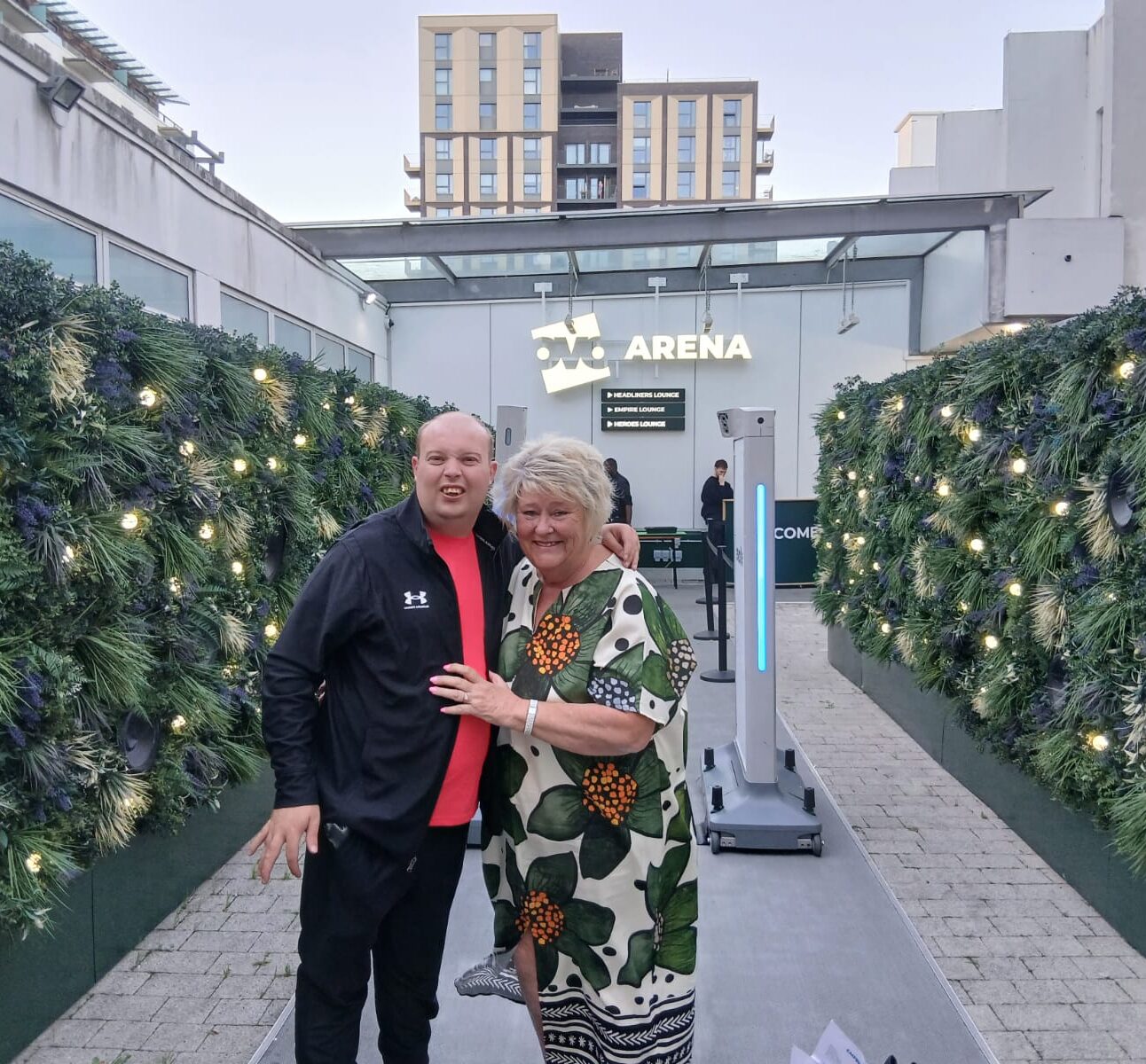 Carl and his support worker Kim are standing outside Wembley