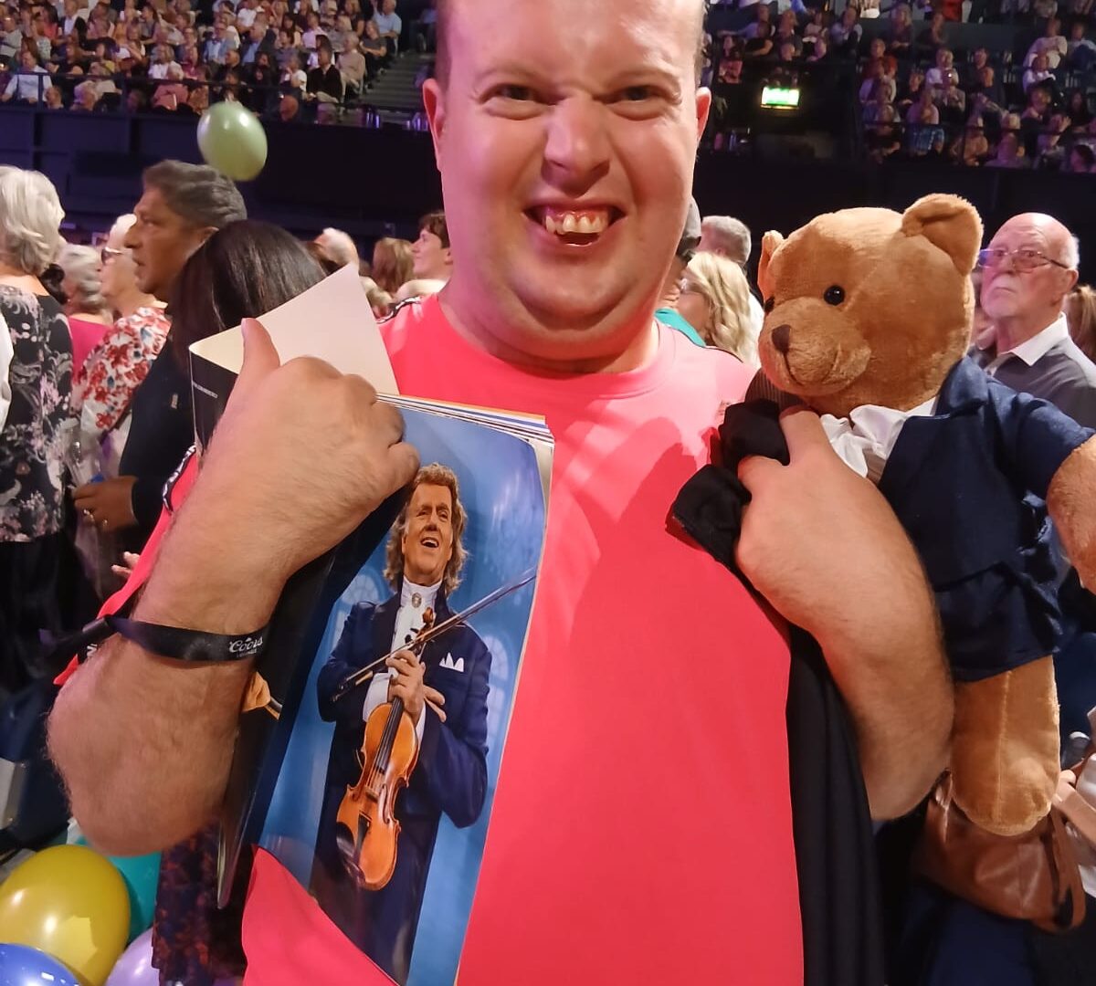 Carl is standing in the crowd at Wembley, with his Andre Rieu merch, grinning.